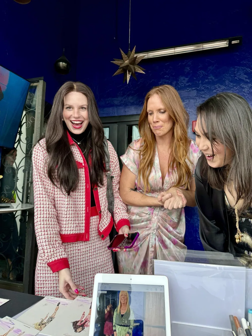 Three guests laughing as they see their sketches at the table