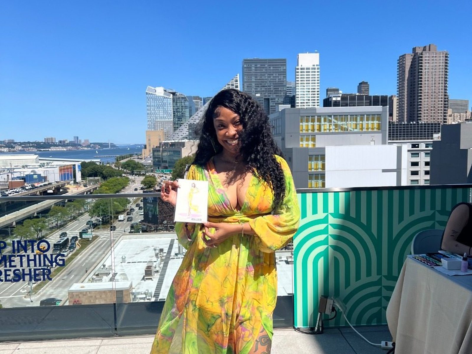 A guest at a rooftop brand activation holding her finished sketch