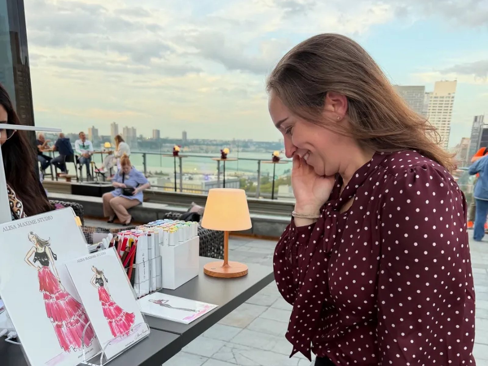 A guest at a rooftop corporate party looking at her sketch