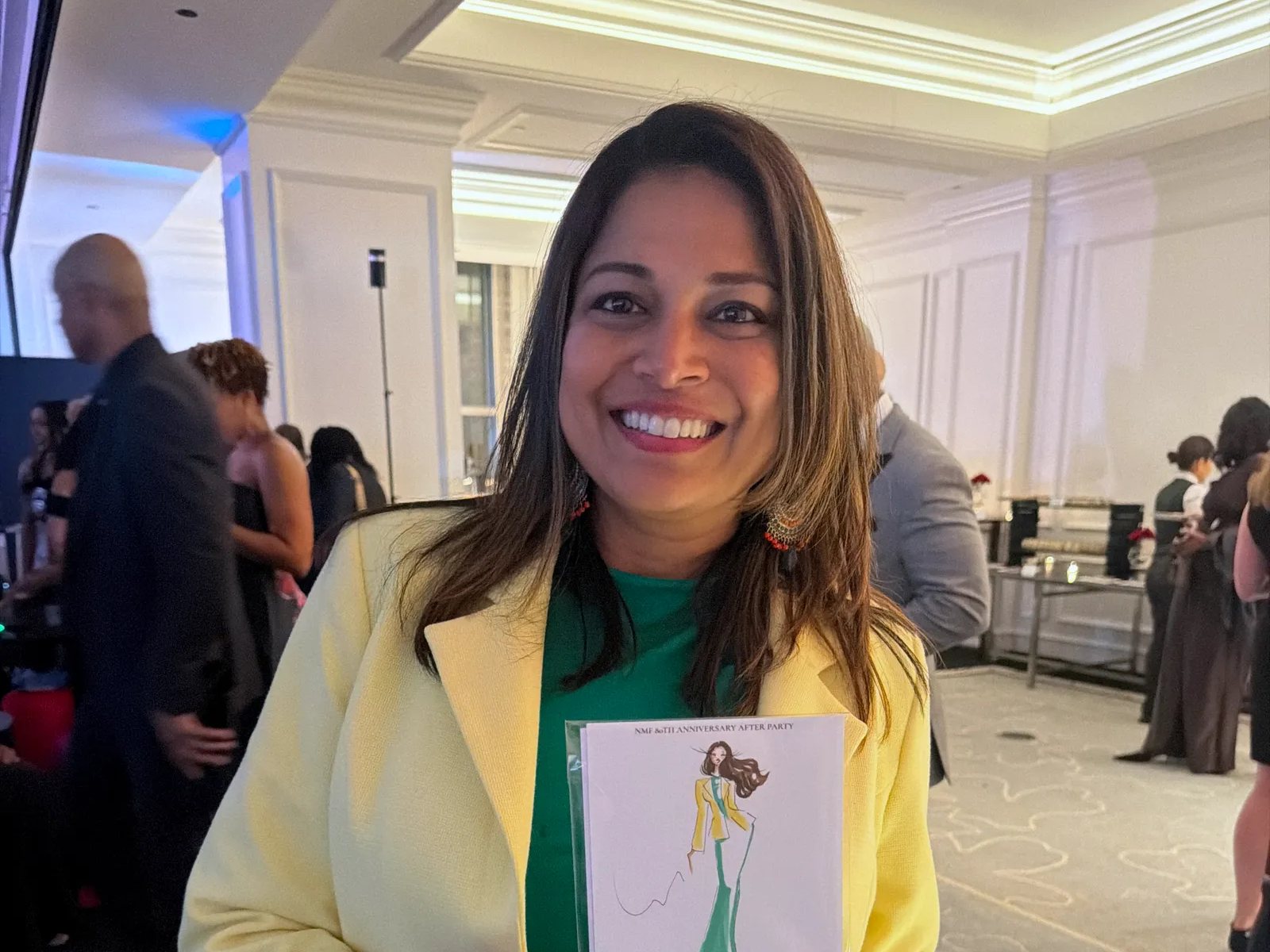A guest at a corporate anniversary party smiling with her sketch