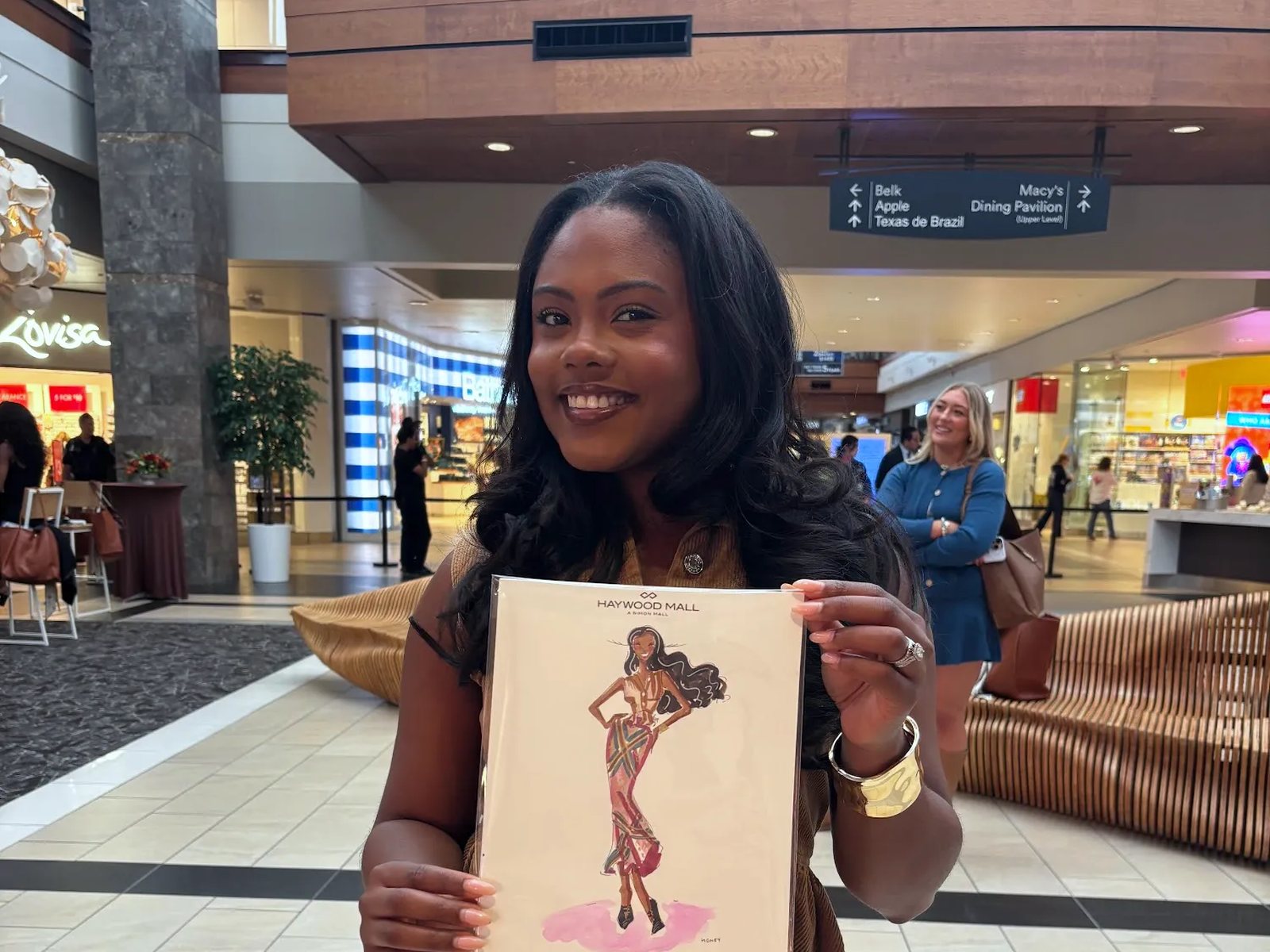 A shopper at a mall event looking at her sketch