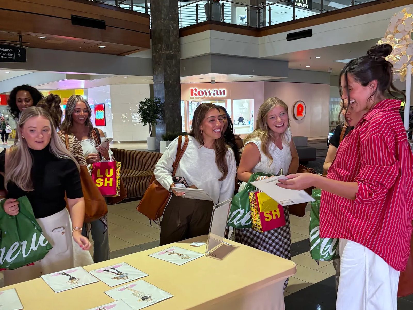 Two shoppers at a mall event with their finished sketches