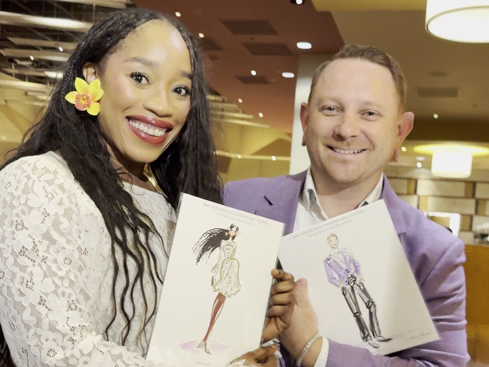 Two guests smiling with their finished sketches