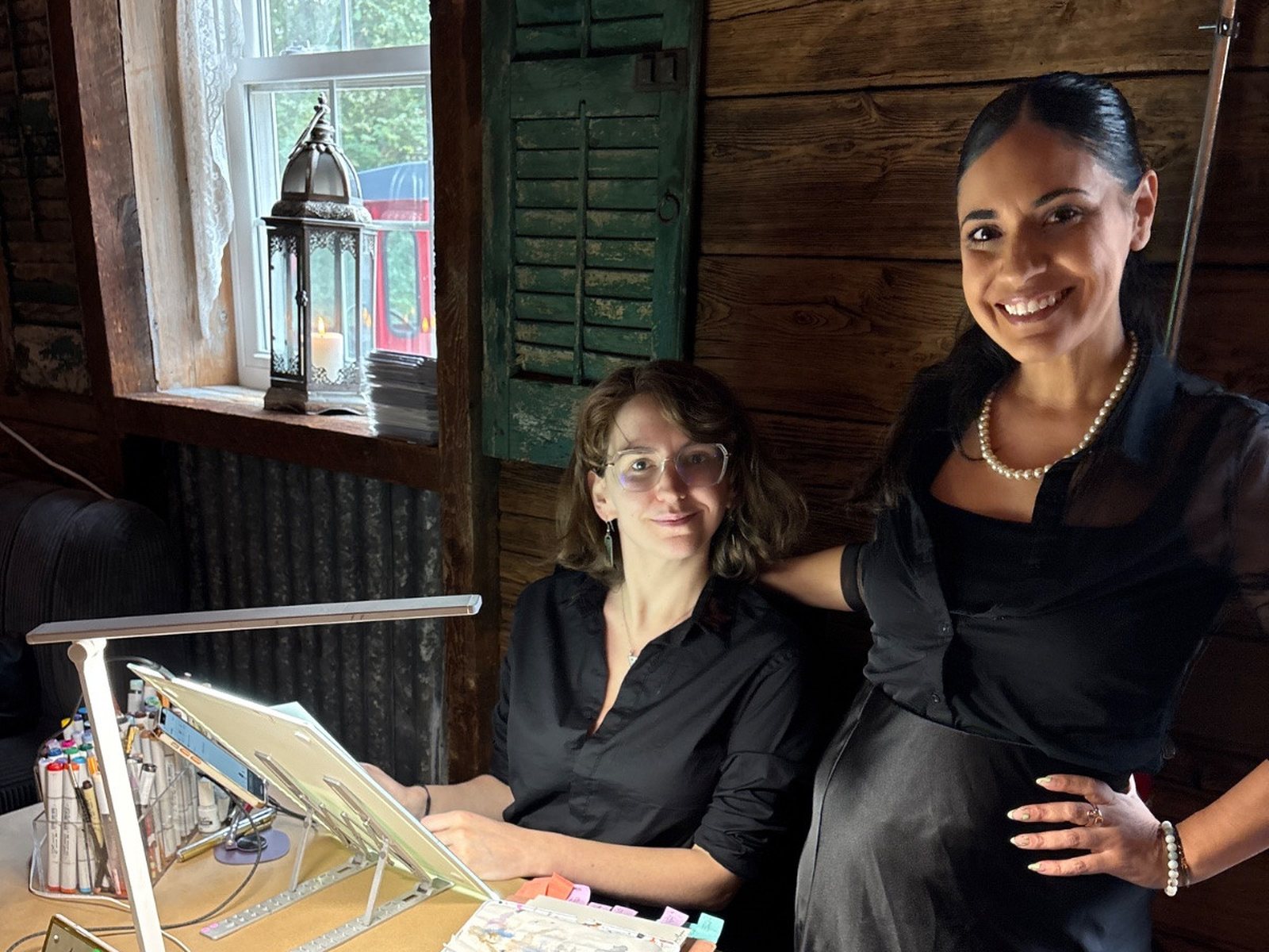 Two artists set up at a barn wedding, before the guests arrive